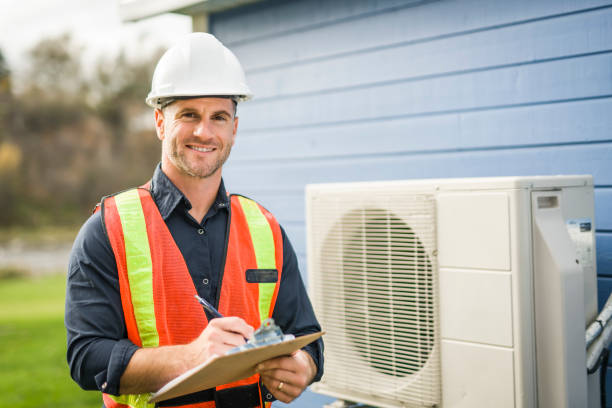 A technician working on air conditioning or heat pump outdoor unit